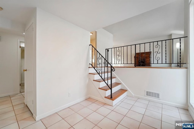 stairs featuring tile patterned flooring, visible vents, and baseboards