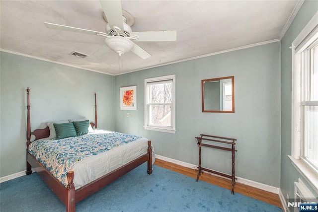 bedroom with ornamental molding, wood finished floors, visible vents, and baseboards