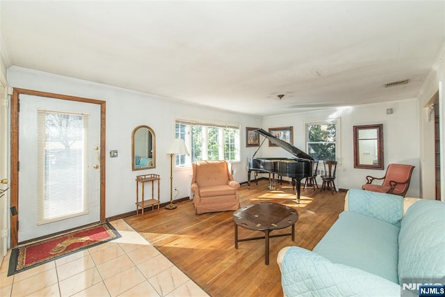 living area with ornamental molding, wood finished floors, and visible vents