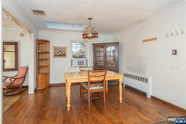 dining room featuring crown molding, dark wood finished floors, visible vents, radiator heating unit, and baseboards