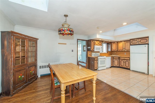 dining area with radiator, light wood finished floors, and ornamental molding