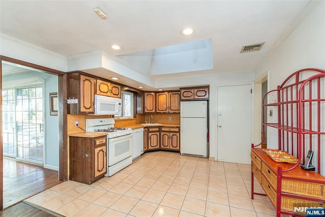 kitchen with white appliances, plenty of natural light, visible vents, ornamental molding, and light countertops