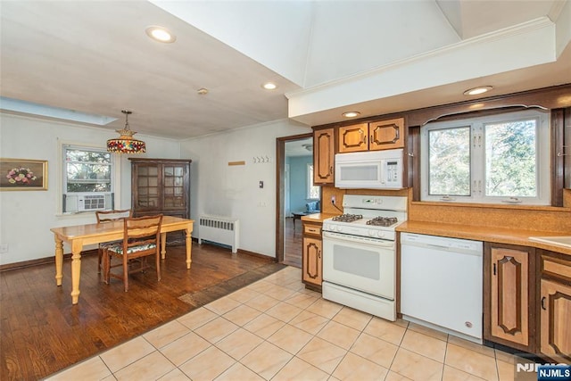 kitchen featuring white appliances, brown cabinetry, radiator, light countertops, and crown molding