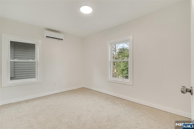 empty room with carpet, a wall mounted air conditioner, and baseboards