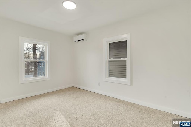 carpeted spare room with baseboards and an AC wall unit