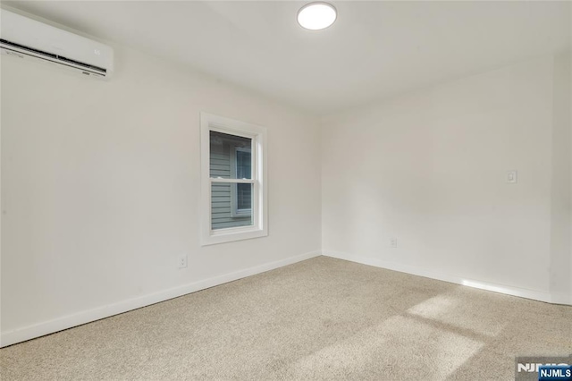 carpeted spare room with a wall mounted air conditioner and baseboards