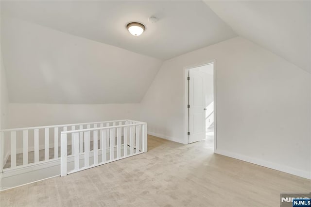 bonus room with lofted ceiling and baseboards