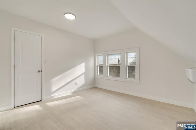 additional living space with lofted ceiling, light wood-type flooring, and baseboards