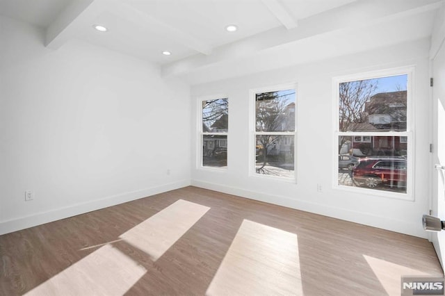 empty room featuring recessed lighting, baseboards, beamed ceiling, and wood finished floors