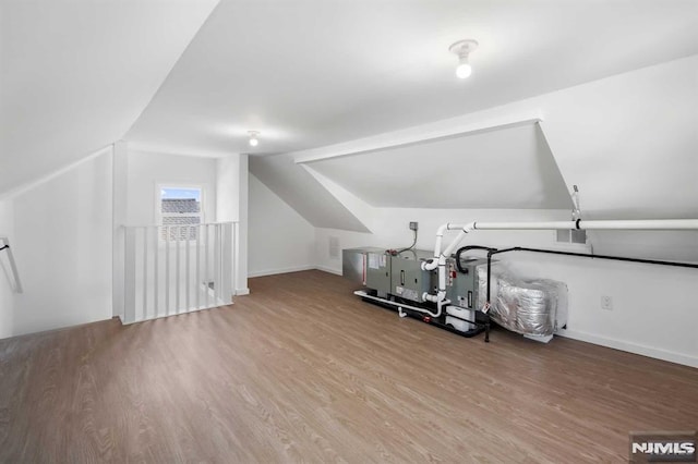 interior space with lofted ceiling, visible vents, baseboards, and wood finished floors