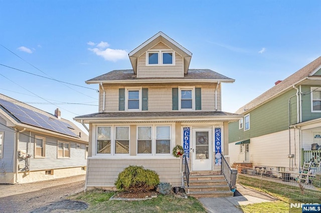 american foursquare style home with entry steps, a shingled roof, and fence