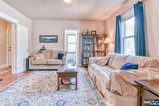 living area with a baseboard radiator, wood finished floors, and baseboards