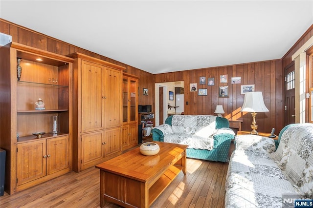 living area featuring wooden walls and light wood finished floors