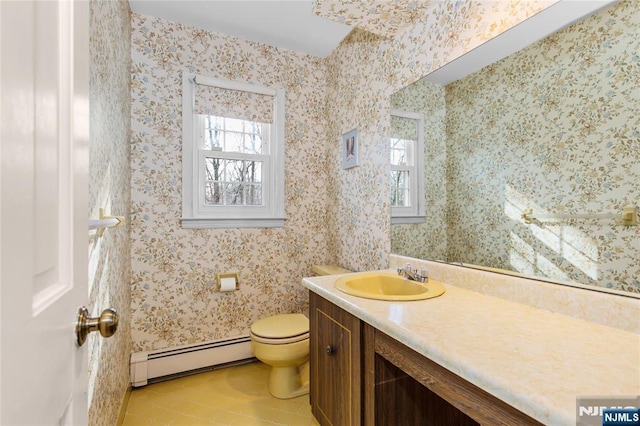 bathroom with a baseboard heating unit, a healthy amount of sunlight, toilet, and wallpapered walls