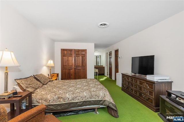 carpeted bedroom with a closet and visible vents