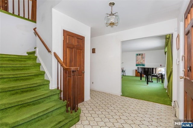 interior space featuring stairway, baseboard heating, an inviting chandelier, light carpet, and baseboards