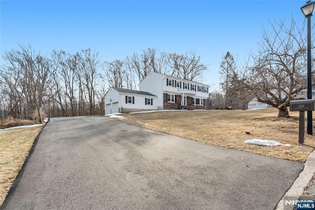 view of front of home featuring driveway and a front lawn