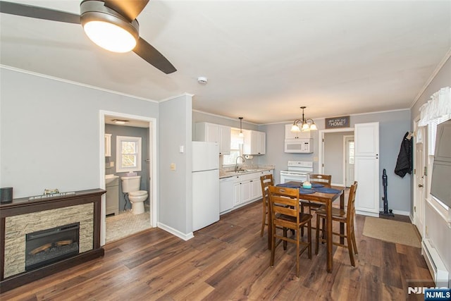 dining room with baseboards, a baseboard heating unit, dark wood finished floors, and crown molding