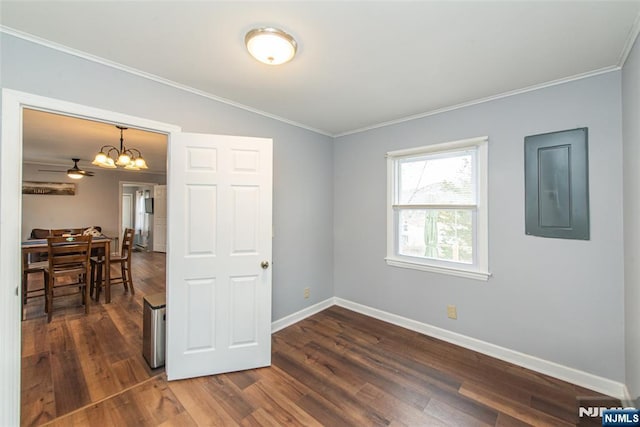 spare room featuring electric panel, baseboards, dark wood-type flooring, and ornamental molding