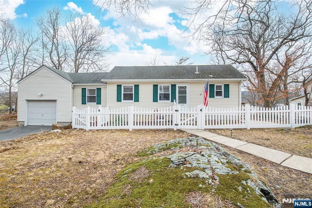 single story home with a fenced front yard, an attached garage, and aphalt driveway