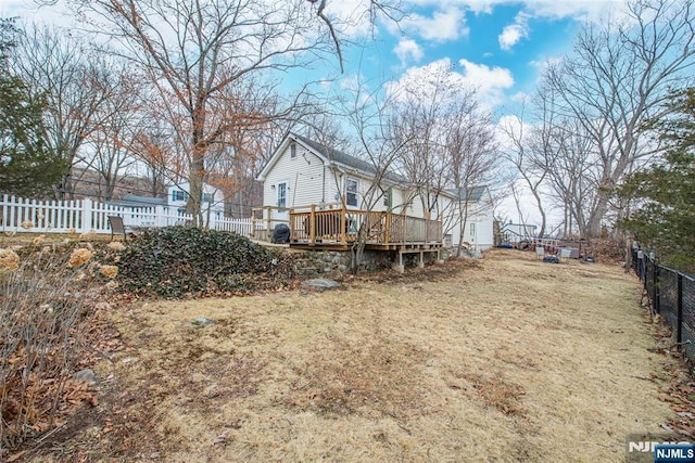 back of property with a fenced backyard and a deck