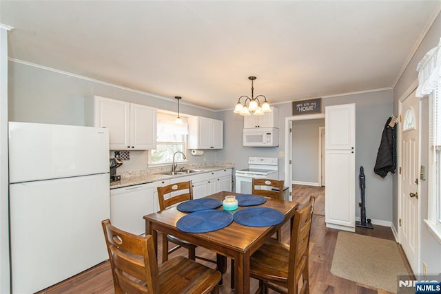 dining area featuring a notable chandelier, ornamental molding, dark wood finished floors, and baseboards