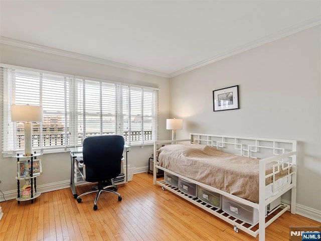 bedroom featuring wood-type flooring, crown molding, and baseboards