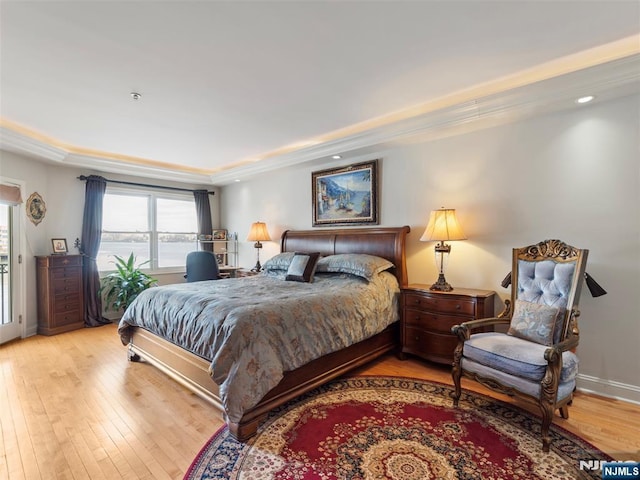 bedroom with wood-type flooring, a tray ceiling, baseboards, and recessed lighting