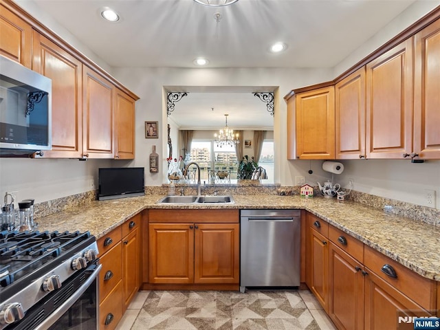 kitchen featuring appliances with stainless steel finishes, brown cabinets, and a sink