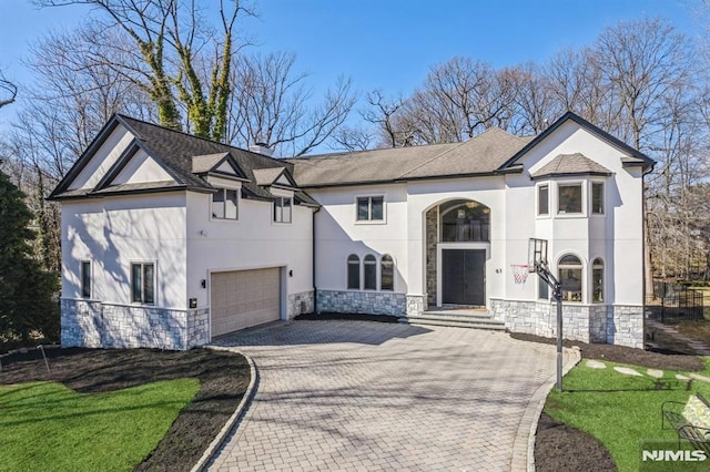 view of front of house with decorative driveway, stone siding, and stucco siding