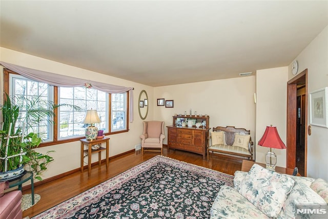 sitting room with baseboards, visible vents, and wood finished floors