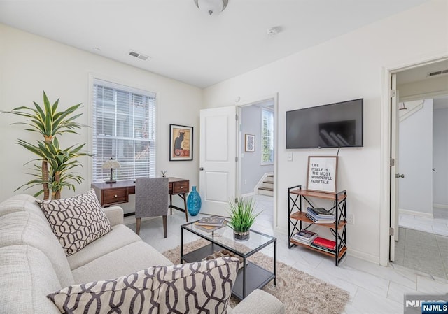 living room with stairway, baseboards, and visible vents