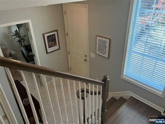 stairs with wood finished floors and baseboards