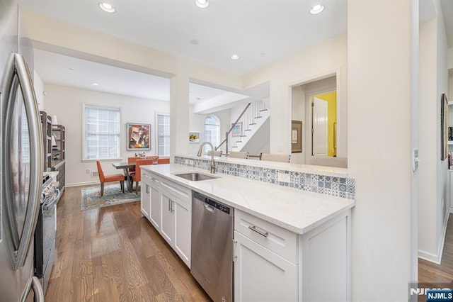 kitchen featuring a sink, recessed lighting, stainless steel appliances, white cabinetry, and dark wood-style flooring