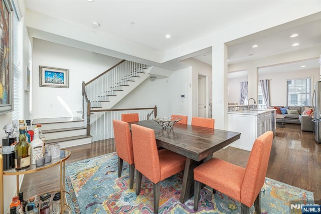 dining room with recessed lighting, wood finished floors, and stairs