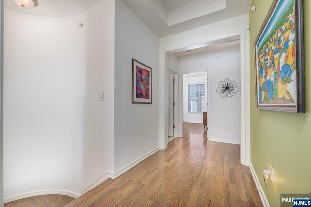 hallway featuring baseboards and light wood-style floors