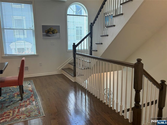 staircase featuring visible vents, baseboards, and wood finished floors