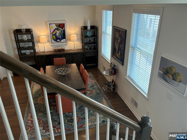 stairs with visible vents, baseboards, a healthy amount of sunlight, and wood finished floors