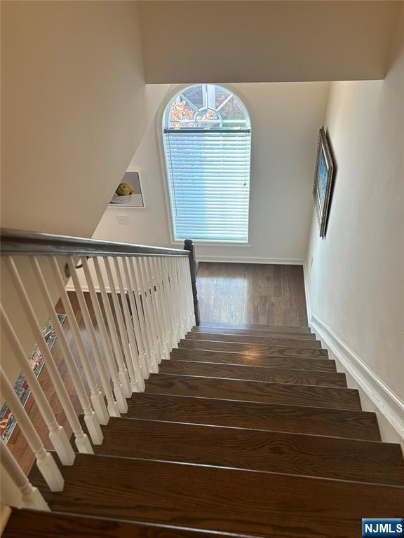 stairway featuring baseboards and wood finished floors