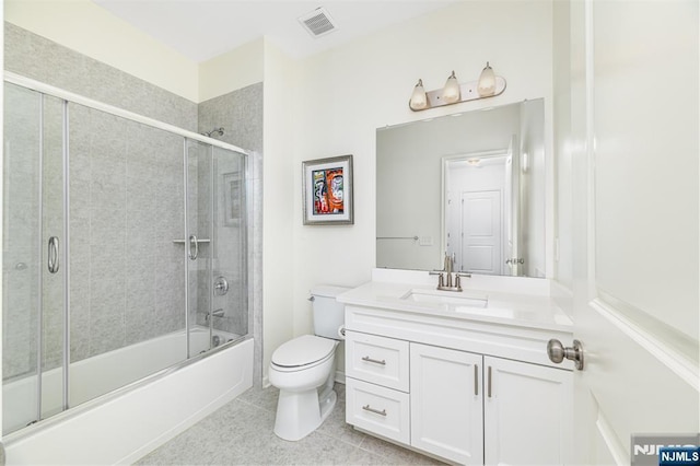 bathroom featuring vanity, visible vents, enclosed tub / shower combo, tile patterned floors, and toilet