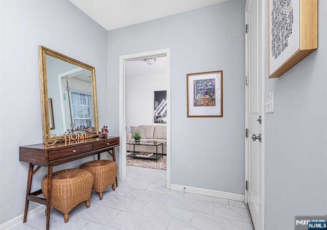 hall featuring baseboards and marble finish floor