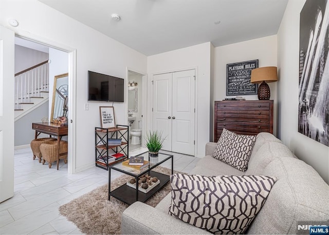 living area with stairway, baseboards, and marble finish floor