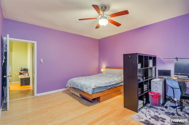 bedroom with ceiling fan, baseboards, and wood finished floors