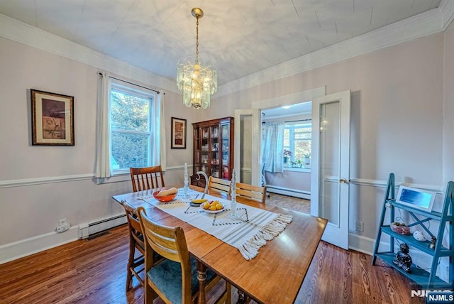 dining room with a baseboard heating unit, wood finished floors, and ornamental molding