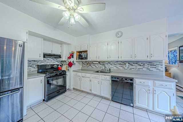 kitchen with black appliances, under cabinet range hood, light countertops, and a sink