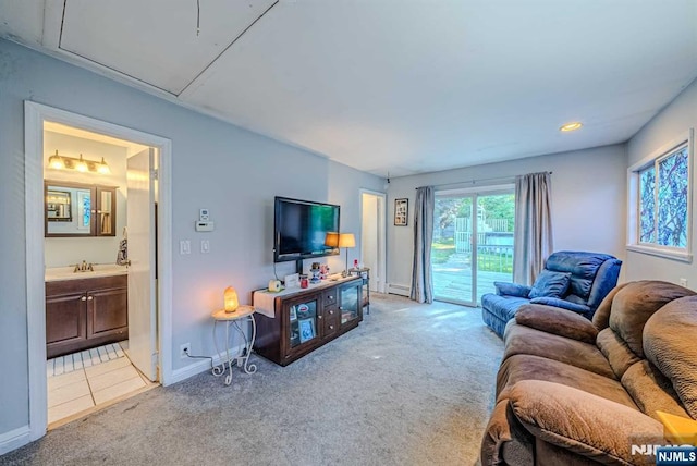 living area with light carpet, a baseboard radiator, attic access, and baseboards