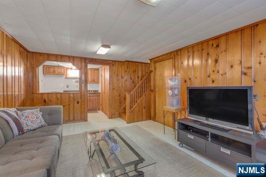 living room with wooden walls and stairway