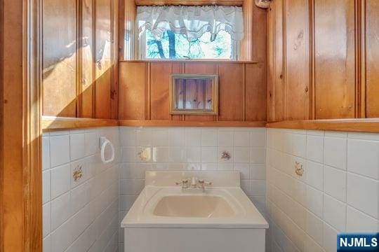 bathroom featuring vanity and tile walls