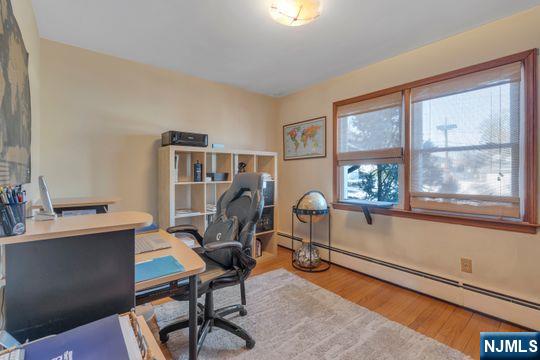 office space with baseboard heating and wood finished floors