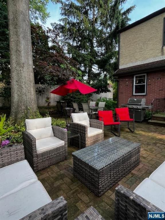 view of patio featuring fence, an outdoor living space, and area for grilling